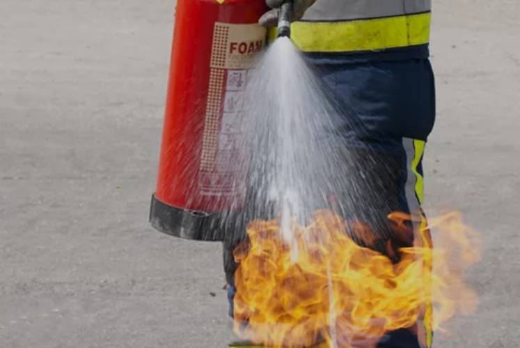 Fire expert extinguishing fire during an on-site training exercise.